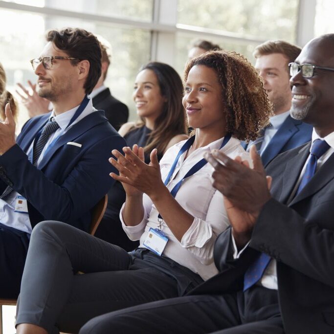 Smiling audience applauding at a business seminar